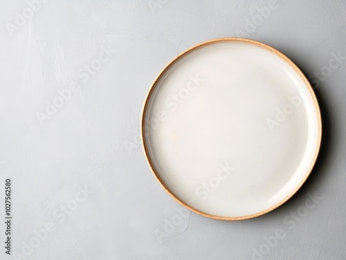 Minimalist top-view of a ceramic plate with a subtle sheen, centered on a muted grey backdrop for modern branding needs