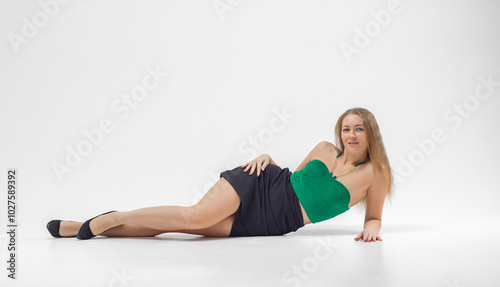 Girl in green top and black skirt poses for camera. She is wearing black heels and necklace. Beautiful sexy body.