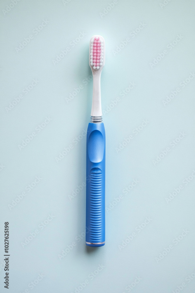 Toothbrush with blue handle on light blue background, concept of dental hygiene Toothbrush with blue handle on light blue background, concept of dental hygiene