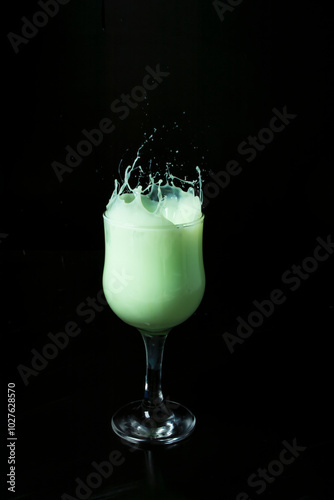copa con jugo verde con salpicaduras