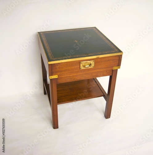 Mahogany side table in military style with green leather table top and brass handles. photo