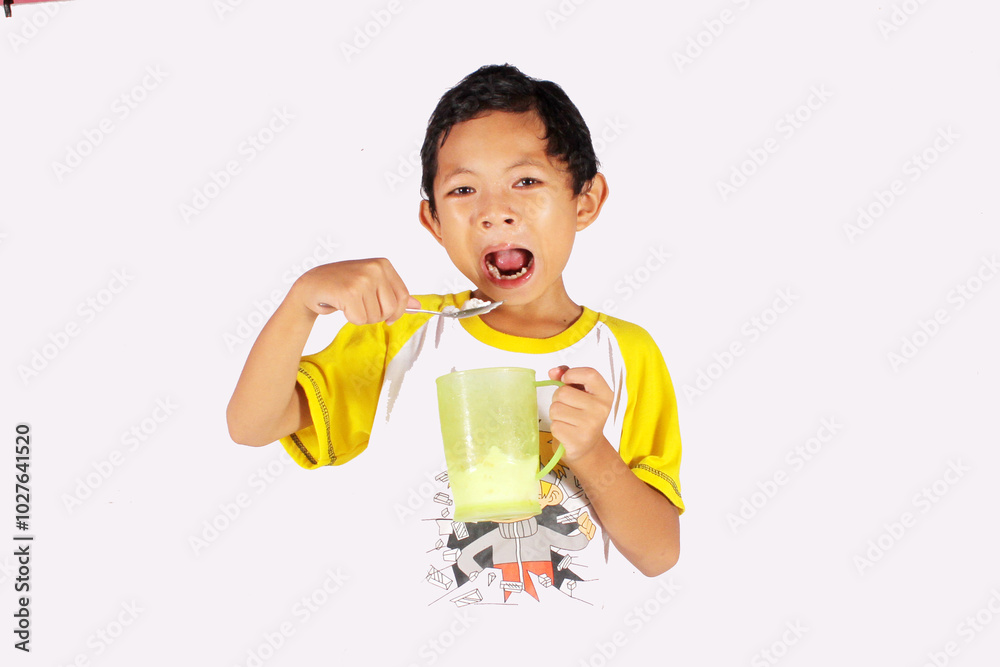 Handsome Indonesian boy, enjoying eating ice cream in a glass Handsome Indonesian boy, enjoying eating ice cream in a glass