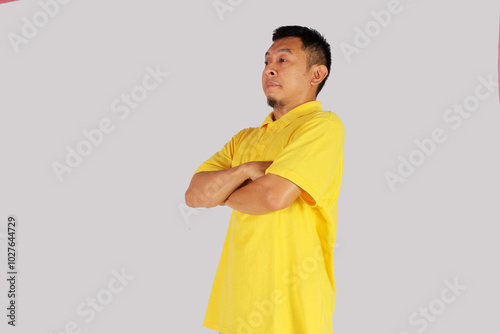 Adult Asian man standing confident with arms crossed showing happy expression
