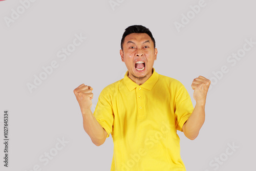 mature asian man showing happy expression with clenched fist
