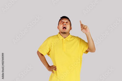 Asian mature man wearing yellow shirt smiling happily after getting a new idea
