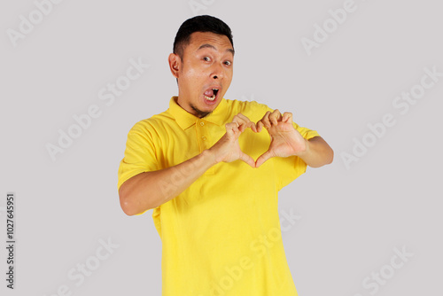 Asian man making a heart shape made of two palms with a happy expression
