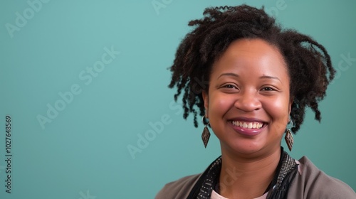 A joyful African-American woman with curly hair smiles warmly, exuding positivity