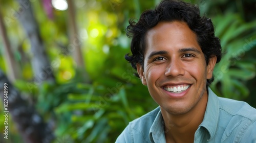 A smiling Hispanic man showcases joy while enjoying the vibrant surroundings of a garden