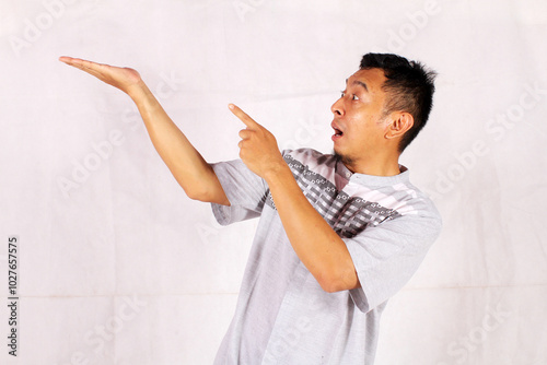 Asian adult man smiling happily after getting a new idea with his pose opening his arms and showing his idea