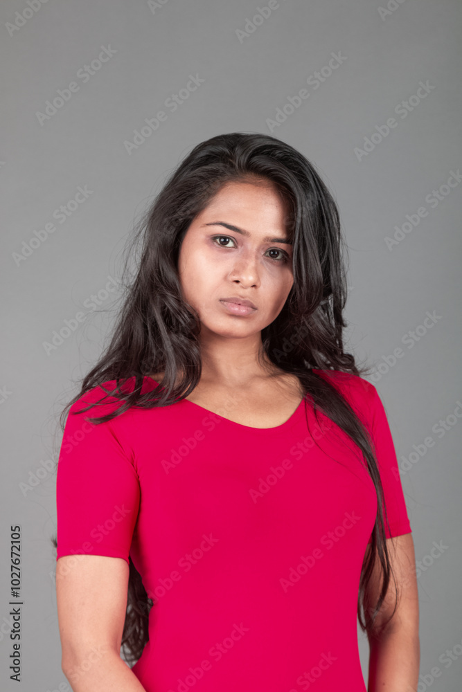 Healthy young woman in red t-shirt and black leggings doing yoga and stretching exercises with different facial expressions, isolated on grey background Healthy young woman in red t-shirt and black leggings doing yoga and stretching exercises with different facial expressions, isolated on grey background