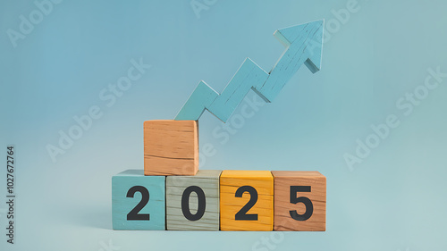 Blue arrow pointing up on wooden blocks with 2025 for New Year success and growth. 