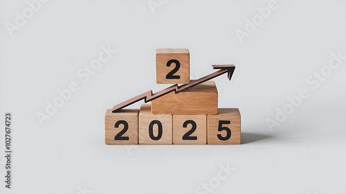 Wooden blocks forming the year 2025 with an upward arrow, representing growth and success in the new year. 
