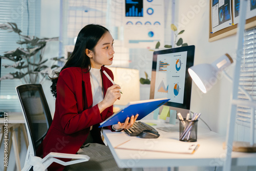 Determined businesswoman working late, analyzing financial data and exploring new opportunities at her office desk with a laptop