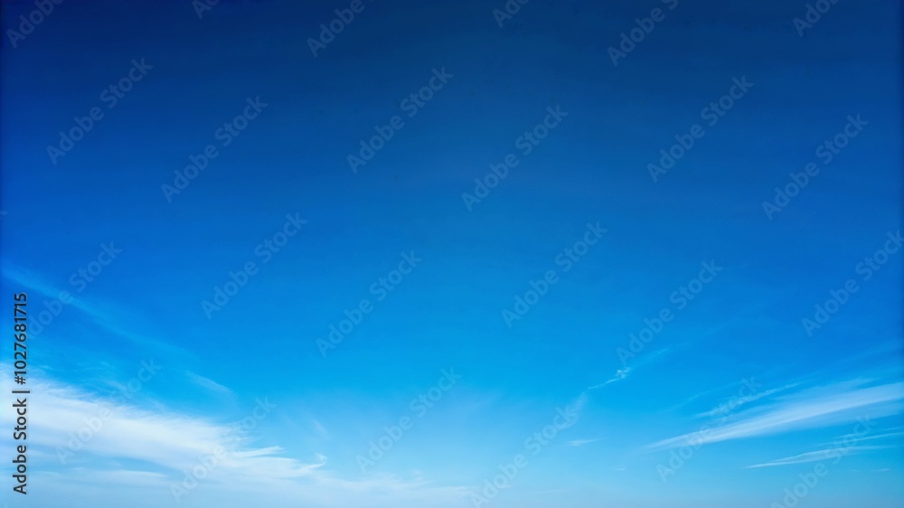 Clear blue sky with light white clouds at bottom of frame Clear blue sky with light white clouds at bottom of frame