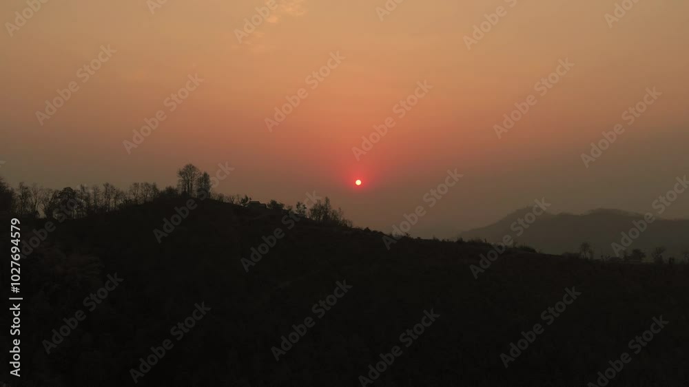 Beautiful Sunset, silhouetted against the warm hues of a setting sun in the hilly region and mountains in the background, Nepal Beautiful Sunset, silhouetted against the warm hues of a setting sun in the hilly region and mountains in the background, Nepal