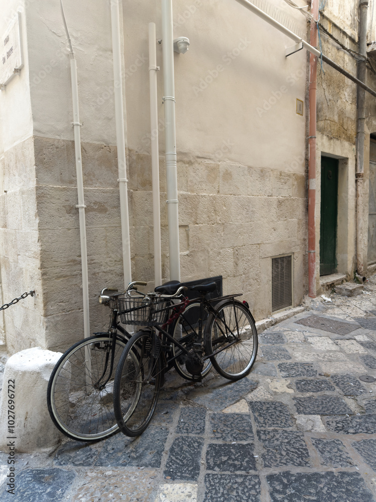 Bicycle in front of a house. Narrow street in the old town center. Polignano a Mare, Puglia, Italy. Bicycle in front of a house. Narrow street in the old town center. Polignano a Mare, Puglia, Italy.