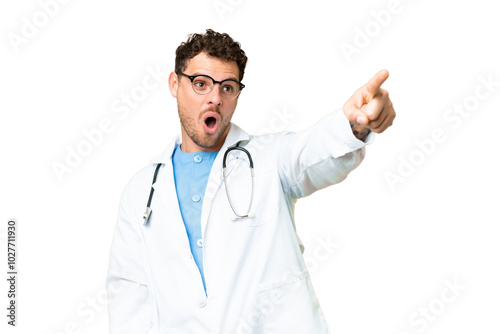 Brazilian doctor man over isolated chroma key background pointing away