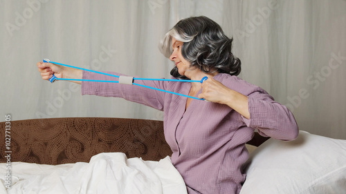 Senior woman doing sport exersise in bed. photo