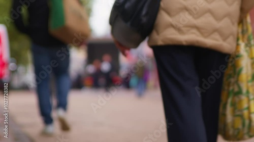 Busy city centre street with pedestrians and shoppers in bokeh. Non-specific representation of city hustle and commercial activity in the UK.