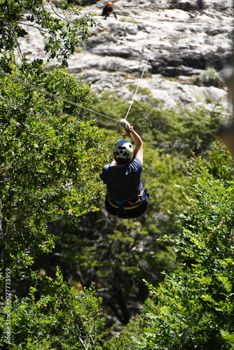 person sliding on a zip line in a forest in the Andes Mountains in southern Chile photo