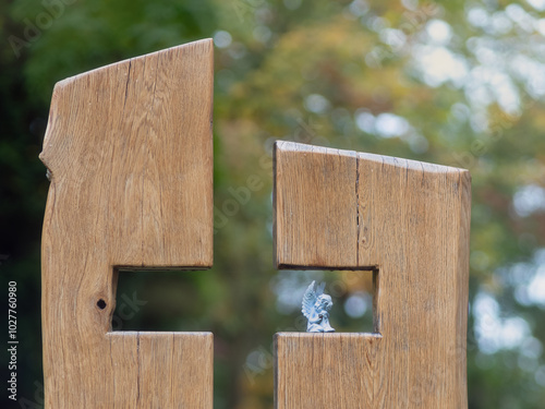 Gestaltetes Holzkreuz aus Eiche und kleiner Engelsfigur, herbstliche Stimmung am Grab photo