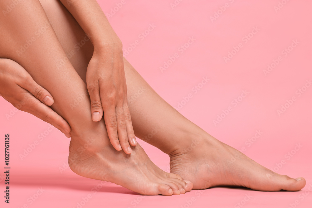 Woman touching her smooth legs on pink background, closeup Woman touching her smooth legs on pink background, closeup
