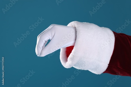 Santa Claus holding something on blue background, closeup