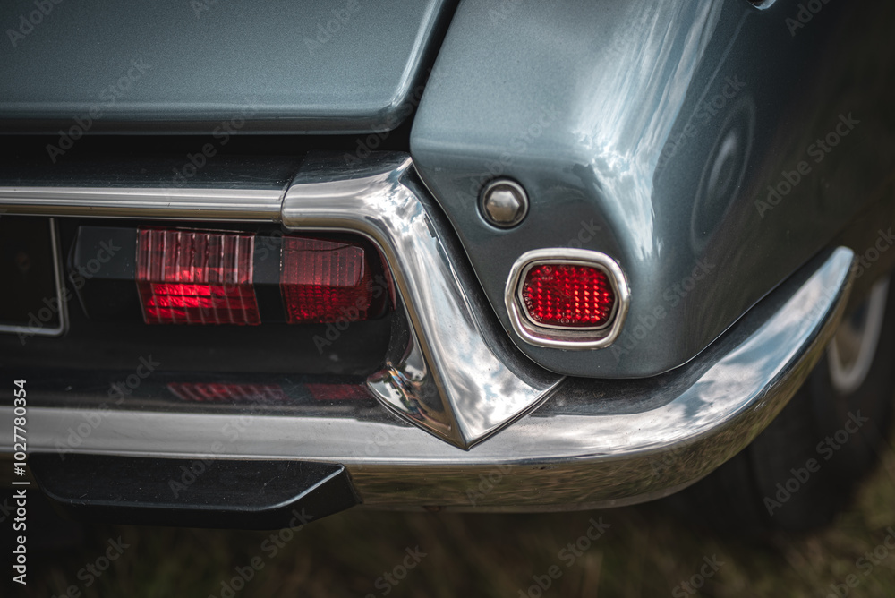 Obraz premium Rear light and a chrome bumper of a old french car on a classic car show.