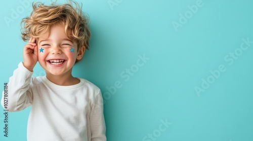 A smiling child with curly hair and star stickers on cheeks, wearing a white shirt. They express happiness and innocence, set against a light blue background.