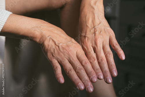 Beautiful hands of mature 50s middle aged woman. Small wrinkles and swollen veins are visible. Beautiful natural manicure