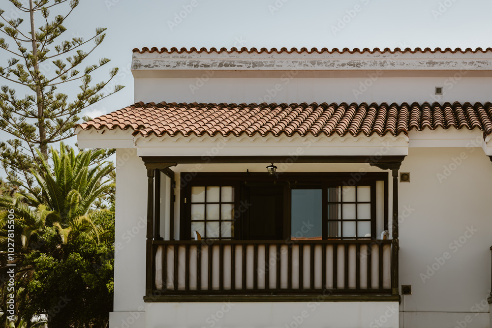 Traditional architecture Canary Islands, Spain. Typical Canarian white house with brown shutters on windows, amazing balcony and orange roof. Building in Puerto de la Cruz, Tenerife. Traditional architecture Canary Islands, Spain. Typical Canarian white house with brown shutters on windows, amazing balcony and orange roof. Building in Puerto de la Cruz, Tenerife.