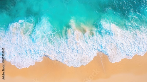 Sunny aerial view of turquoise water with waves splashing and a bright, sandy beach stretching out from the top view