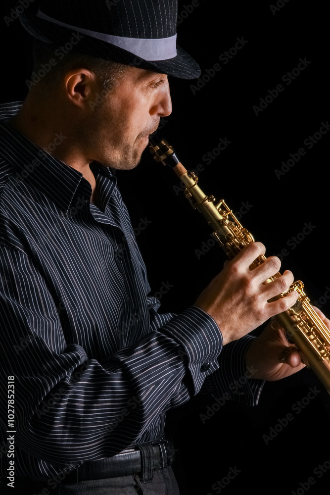 Naklejka premium soprano saxophone in the hands of a guy on a black background