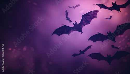 Silhouettes of bats flying across a gradient night sky, transitioning from deep purple to black photo