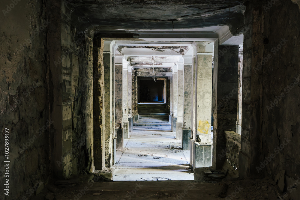 Dark, decaying hallway in abandoned building, crumbling walls and debris scattered on floor. Dark, decaying hallway in abandoned building, crumbling walls and debris scattered on floor.