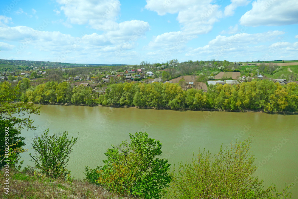 Panorama with a small beach located on the river bank. Village on the river bank Panorama with a small beach located on the river bank. Village on the river bank
