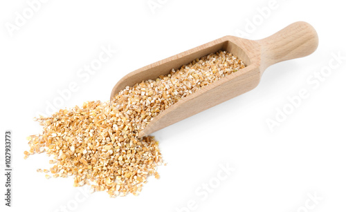 Dry wheat groats in wooden scoop isolated on white photo