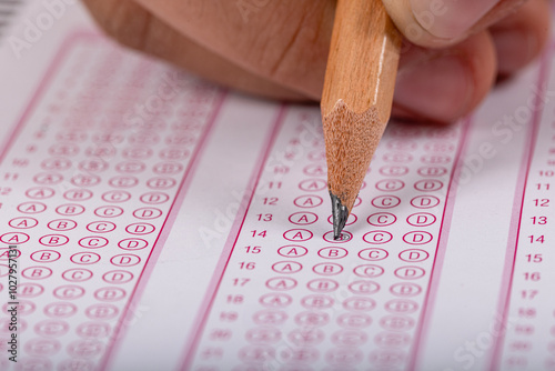 Exam, a hand taking an exam with a pen on an optical reader. Exam, an idea concept. Anxiety about the future, uncertainty. Multiple choice exam. Adults taking an exam. photo