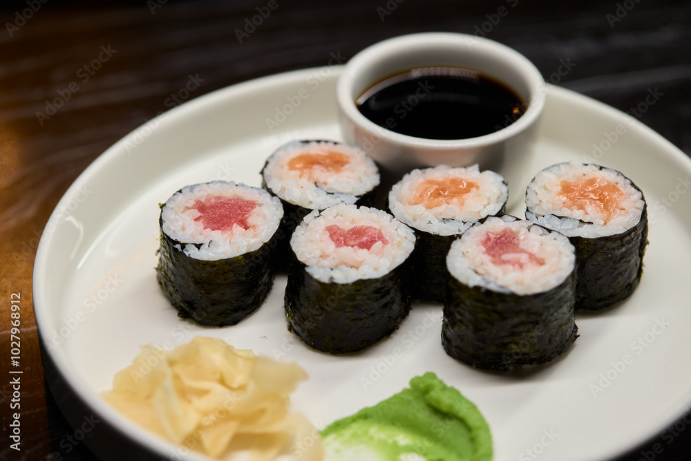 A Beautiful Plate Filled with Delicious Sushi Rolls Accompanied by Soy Sauce for Dipping A Beautiful Plate Filled with Delicious Sushi Rolls Accompanied by Soy Sauce for Dipping