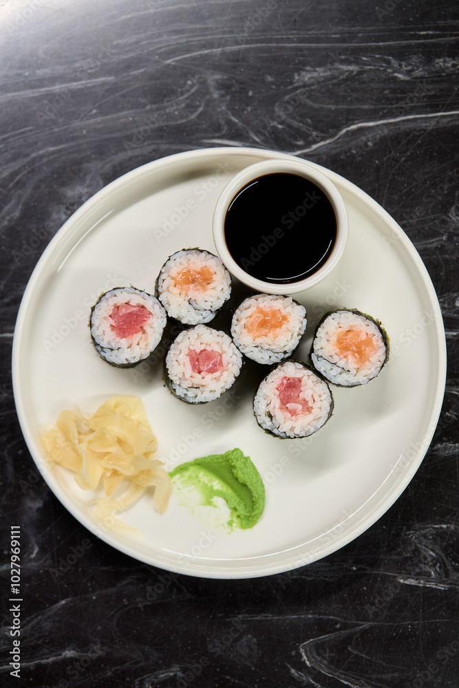 A Beautiful Plate Filled with Delicious Sushi Rolls Accompanied by Soy Sauce for Dipping A Beautiful Plate Filled with Delicious Sushi Rolls Accompanied by Soy Sauce for Dipping