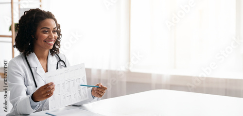 Smiling african doctor dietologist showing patient black woman treatment plan during consultation in clinic photo