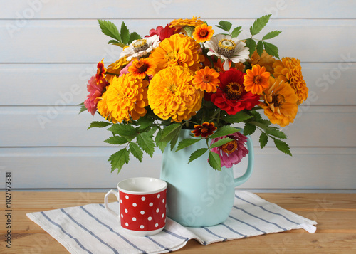 still life with a bouquet of flowers in a jug. zinnias. a summer rural composition.