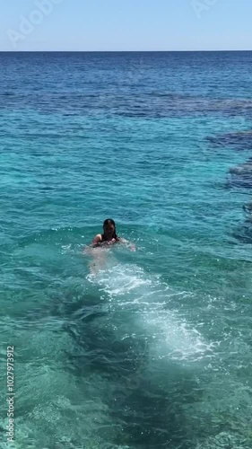 Brave young girl jumping off a cliff