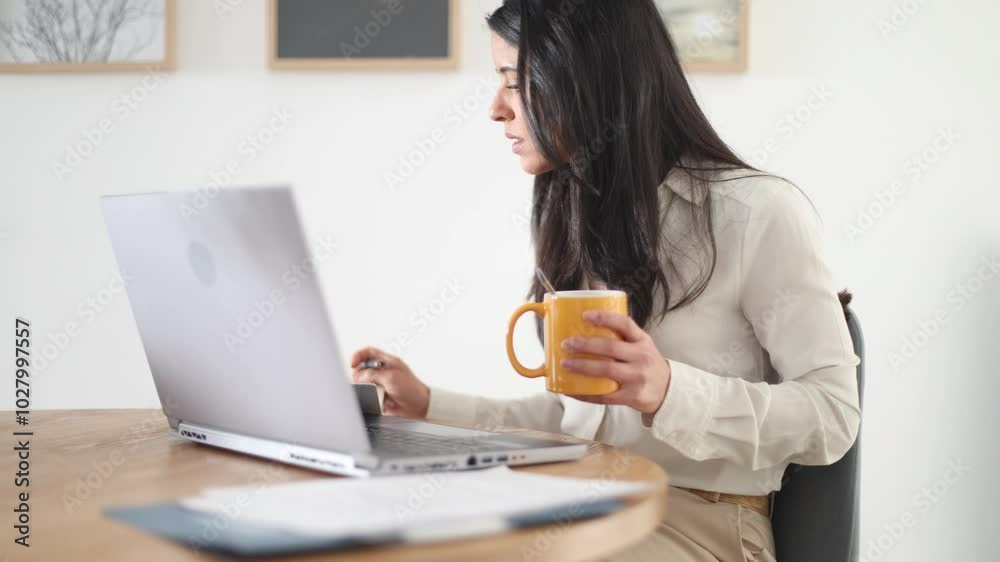 Businesswoman working at her desk grows increasingly frustrated while reviewing paperwork and facing mounting pressure Businesswoman working at her desk grows increasingly frustrated while reviewing paperwork and facing mounting pressure