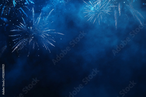 Blue fireworks bursting in the distance with mist and smoke filling the dark sky
