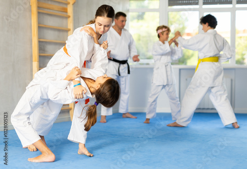Quadro su tela Young boys and girls athletes in white kimonos practice Brazilian jiu Jitsu Aikido Wing chun wrestling