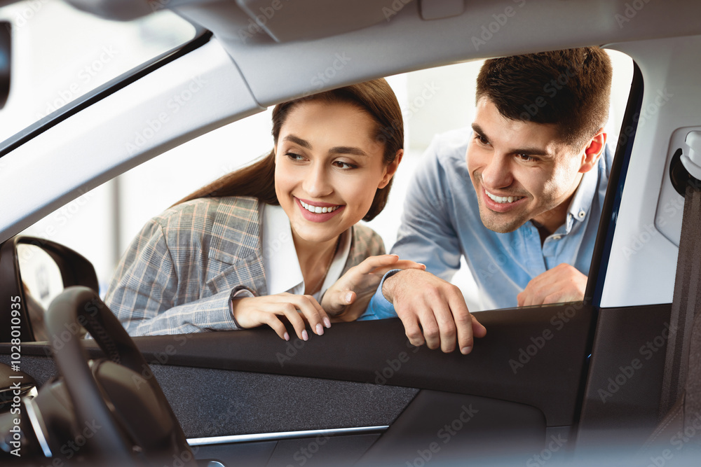 New Transport. Happy Husband And Wife Looking At New Auto Together, View From The Inside Of The Car. Copy Space New Transport. Happy Husband And Wife Looking At New Auto Together, View From The Inside Of The Car. Copy Space