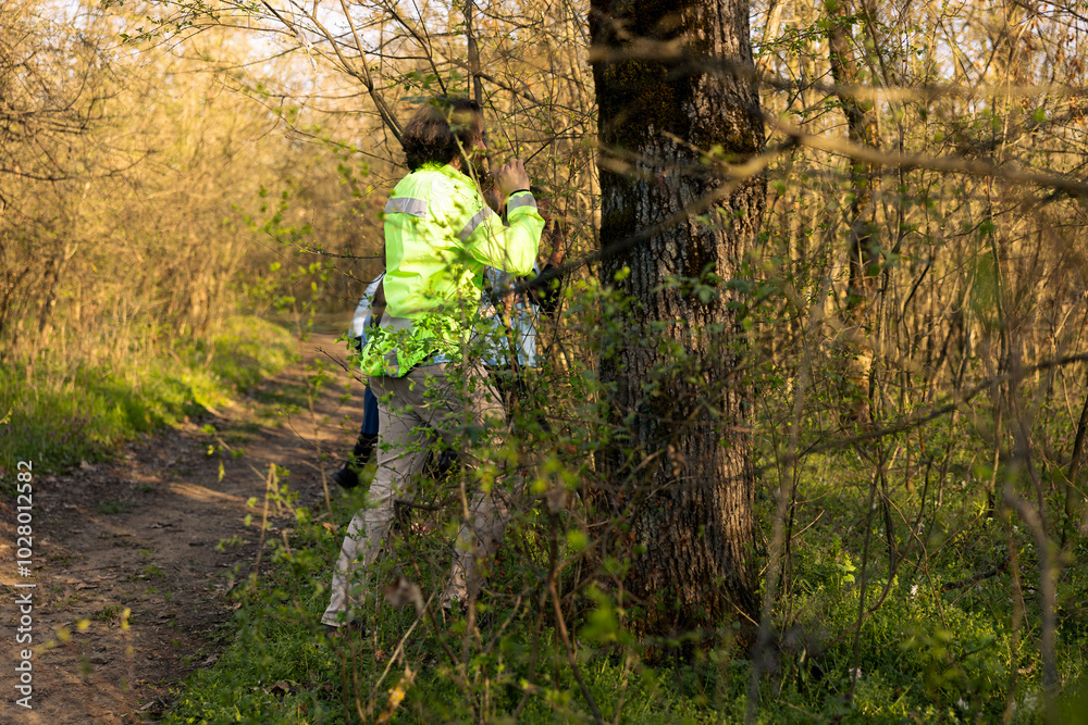 Civilian search party starting the manhunt within the woodland area, shouting the missing person name and tracking footsteps. Rescuers team looking for evidence and details, emergency. Civilian search party starting the manhunt within the woodland area, shouting the missing person name and tracking footsteps. Rescuers team looking for evidence and details, emergency.