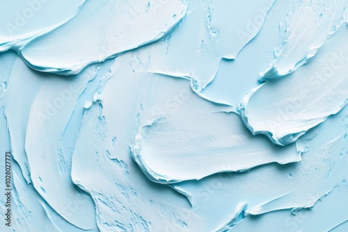 Smooth cream texture smeared across a pastel blue background showcasing a tranquil cosmetic aesthetic