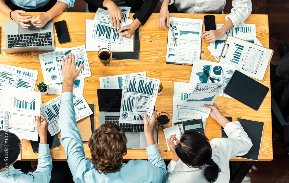 Obraz premium Panorama top view diverse group of business analyst team analyzing financial data report paper on meeting table. Chart and graph dashboard by business intelligence analysis. Meticulous